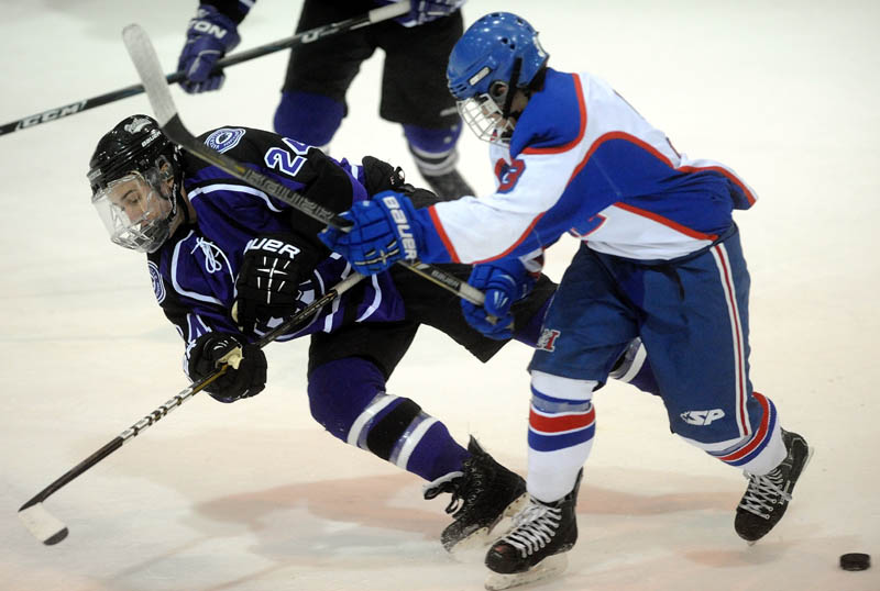 BATTLE FOR THE PUCK: Messalonskee High School’s Josh Towle, right, checks Waterville Senior High School’s Zach Disch in the first period Wednesday at Sukee Arena in Winslow.