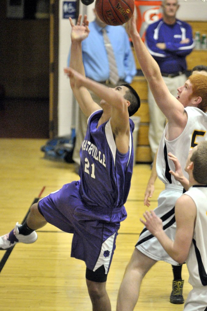 Waterville junior guard Christopher Hale, left, gets shot blocked by Maranacook senior center Andrew Lachance during a game Friday at Maranacook Community School in Readfield.
