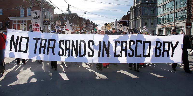 People march down Commercial Street in Portland on Saturday to protest what they say is an emerging proposal to send tar sands oil from Canada through a pipeline to Portland harbor. Officials with the Portland Pipeline Corp., which owns the pipeline, says there is no existing proposal to send tar sands oil through the pipeline.