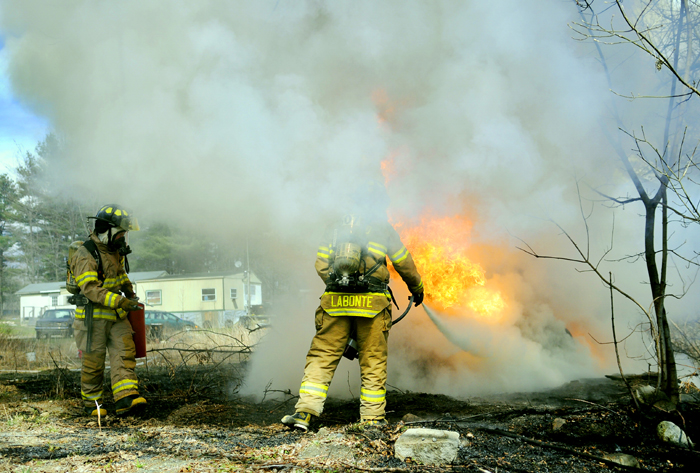 Firefighters extinguish flames from a chemical storage tank in Manchester, which erupted when Edward T. Bishop, 34, of Oakland, cut into the tank, burning him seriously, on April 10. Bishop is suing MaineGeneral Medical Center and the town of Manchester over the incident.