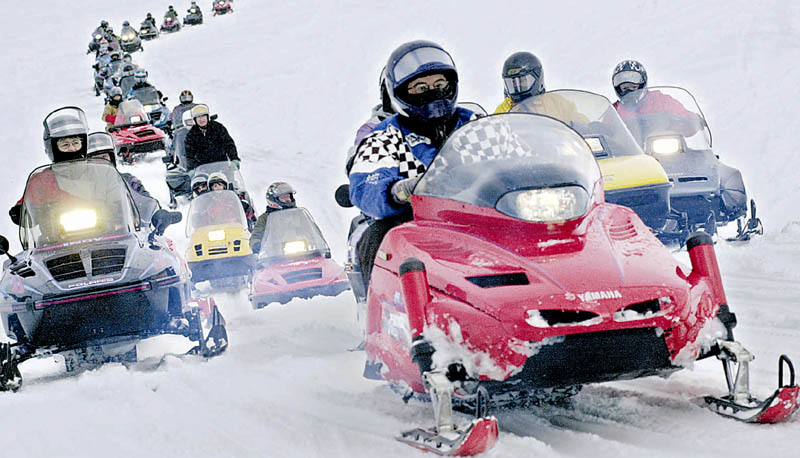 A parade of snowmobiles makes its way across Sebasticook Lake in Newport. Riders are being urged to use caution, especially around early season hazards, such as unstable ice.