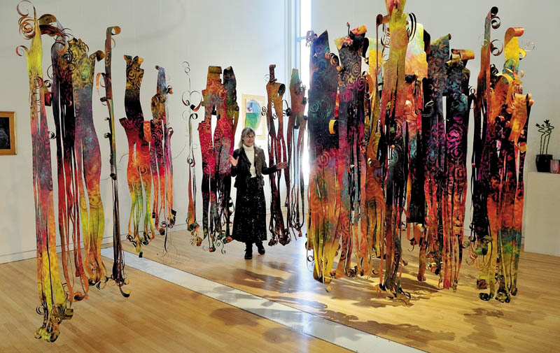 Artist Dona Seegers, of Mount Vernon, walks through her art work, titled "Spirit Dance," at the Emery Community Art Center in Farmington on Thursday.