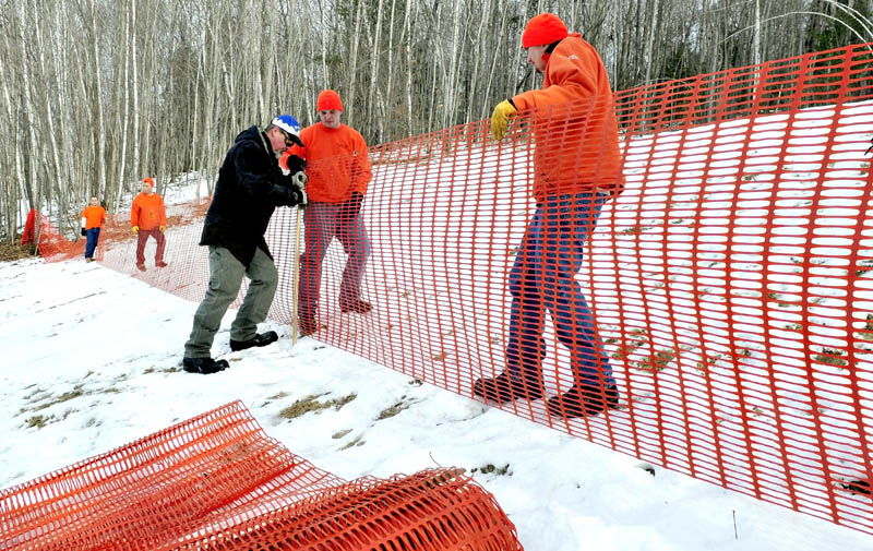 Steven Buzzell, center, of the Waterville parks and recreation department, works with Kennebec County jail inmates Joey Johnson, right, and Shawn Peaslee on a fence for the sledding hill at the Quarry Road Recreation Area in Waterville on Monday. The Winter Carnival runs Saturday from 10 a.m. to 2 p.m. and features sledding, snowshoe races, ski instruction, a bonfire, food and the Amazing Tree Maze.