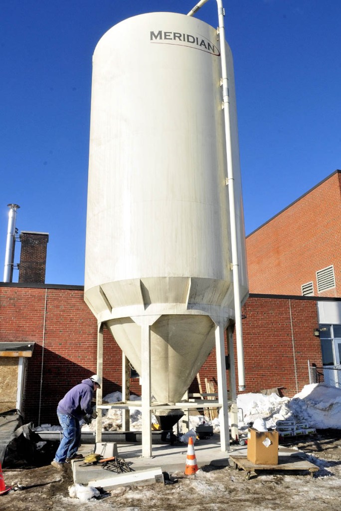 Trevor Lawlor works on the wood pellet storage silo outside the Skowhegan Area High School on Thursday.