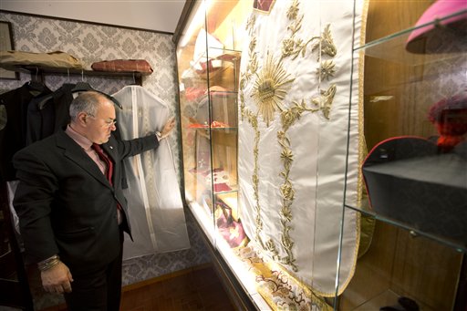 A man looks at cardinal robes in the Gammarelli clergy clothing shop, in Rome, Wednesday, Feb. 20, 2013. For over a half century the Gammarelli family has produced the pope robes in three different sizes that are delivered before the conclave meets, in order to fit the newly elected popes. Pope Benedict XVI may issue a decree that would bring forward the conclave tasked with electing his successor before a date in mid-March scheduled under the current rules, the Vatican said today. (AP Photo/Andrew Medichini)