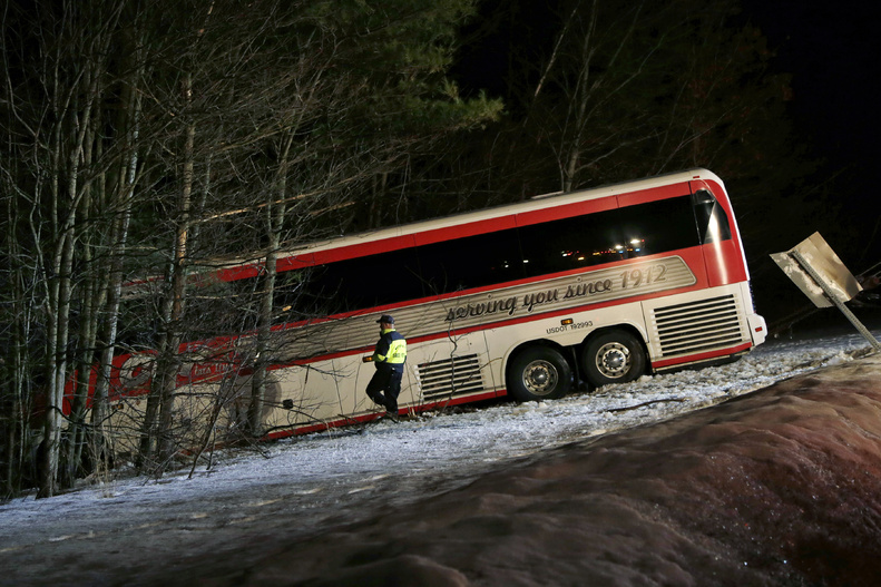 Police work at the scene in Georgetown, Mass., on Tuesday where a bus carrying University of Maine women's basketball players crashed on Interstate 95 north of Boston.