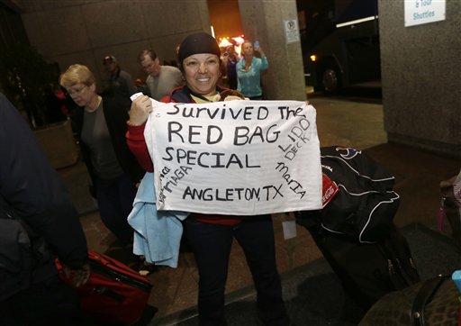 Veronica Arriaga, of Angleton, Texas, a passenger from the disabled Carnival Triumph cruise ship, holds a sign referring to the red biohazard bags used as toilets, as she arrives at the Hilton Riverside Hotel in New Orleans on Friday.