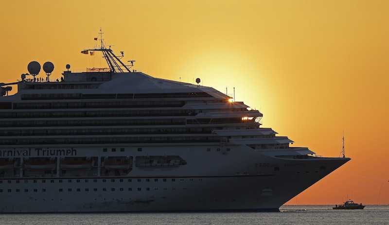 The cruise ship Carnival Triumph is towed into Mobile Bay near Dauphin Island, Ala., Thursday, Feb. 14, 2013. The ship with more than 4,200 passengers and crew members has been idled for nearly a week in the Gulf of Mexico following an engine room fire. (AP Photo/Dave Martin)
