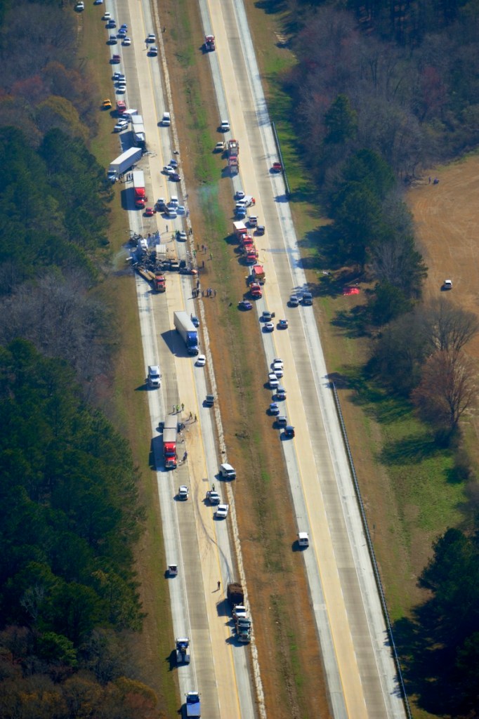 Cars and trucks are strewn along the road after a major pileup on Interstate 16 near the Jeffersonville, Ga. early Wednesday morning Feb. 6, 2013. More than two dozen vehicles collided in a fiery pileup on the foggy Georgia interstate killing at least three people and leaving several others hurt, officials said. (AP Photo/The Macon Telegraph, Woody Marshall)