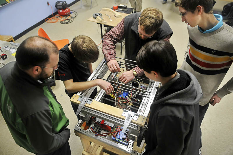 Members of the Gardiner Area High School robotics team wire the robot they are building Thursday at the high school. The completed robot will launch Frisbees into goals while being operated remotely, at an April competition.