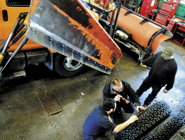 Augusta Public Works mechanics Jason Arbour, left, and Rick Merrill inspect plow tires with shop foreman Shawn Harrington, Monday, at the city's garage.