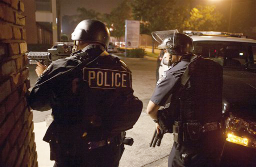 Police respond in Riverside, Calif., early Thursday morning, in search of the former LAPD officer accused of killing one police officer and critically wounding another.