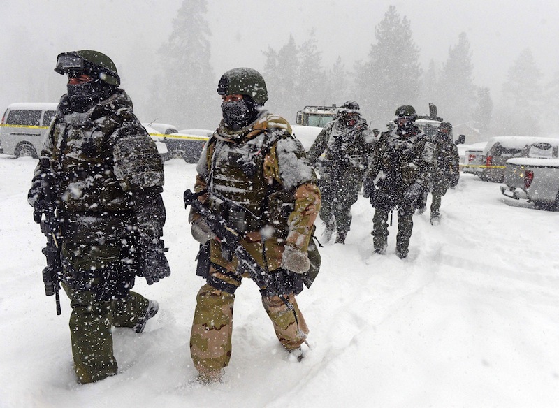 A San Bernardino County Sheriff SWAT team returns to the command post at Bear Mountain near Big Bear Lake, Calif. after searching for Christopher Jordan Dorner on Friday, Feb. 8, 2013. Search conditions have been hampered by a heavy winter storm in the area. Dorner, a former Los Angeles police officer, is accused of carrying out a killing spree because he felt he was unfairly fired from his job. (AP Photo/Pool, The Inland Valley Daily Bulletin, Will Lester)