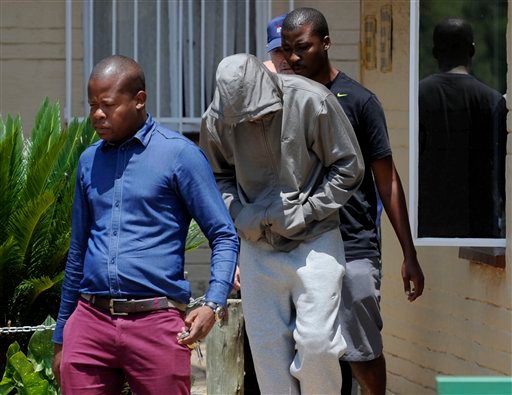 Olympic athlete Oscar Pistorius, center. leaves the Boschkop police station, east of Pretoria, South Africa, on Thursday en route to appear in court to be charged with murder.
