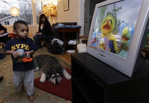 Nancy Jensen, second from left, looks on as her son Joe, 2, is given a special treat of a little TV time last week at their home in Seattle. Nancy Jensen was a participant in a new University of Washington study on the effects of television viewing on kids that will be published Monday.