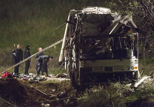 Investigators early Monday work at the scene of the crash that killed at least eight people and injured 38 near Yucaipa, Calif.