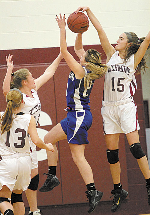 BLOCKING IT: Richmond High School’s Jamie Plummer blocks a shot by Old Orchard Beach’s Abby Dubois with help from teammate Brianna Snedeker, left, as Noell Acord (13) looks on during the first half Tuesday night in Richmond.
