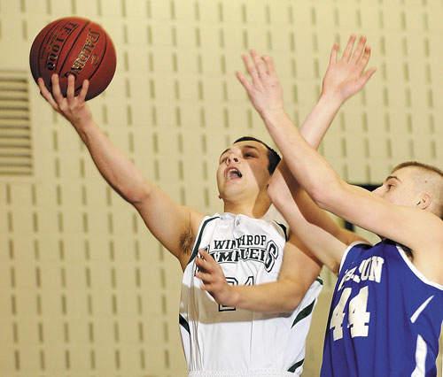TO THE HOLE: Winthrop’s Crispin Banda, left, tries to take a shot past Madison’s Steven Lawrence on Friday at Winthrop High School.