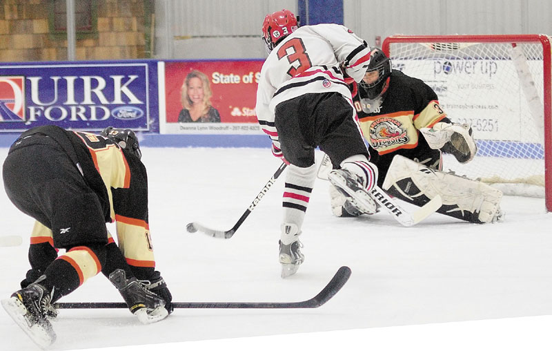 Cony's Dallas Clark, center, gets past Brunswick defenseman Tyler Sullivan, left, to shoot and score on Brunswick keeper Blake Alexander to tie the score 1-1 in first period of a hockey playoff game on Tuesday February 26, 2013 at the Bank of Maine Ice Vault in Hallowell.