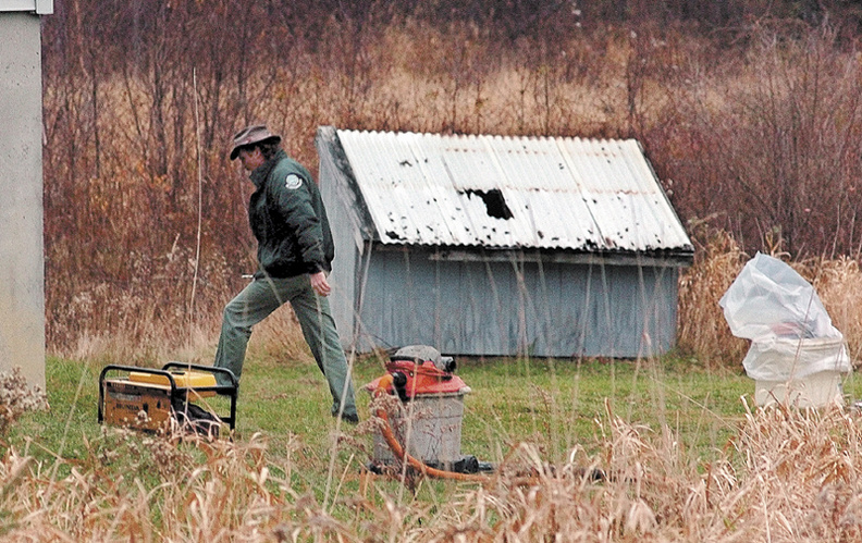 Jon Andrews, an oil and hazardous materials specialist with the Department of Environmental Protection, enters a residence off Drummond Road in Sidney.