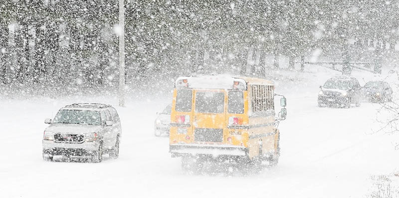 Staff photo by Joe Phelan Cars drive in on Pierce Drive as buses leave Cony High School at 10:45 a.m. on Friday February 8, 2013. Students were released early for the winter storm in Augusta.