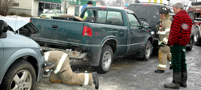 Tom Proctor, 57, of Moscow, in plaid jacket, watches after his green Chevrolet pick-up truck was involved in an accident Friday morning. The truck was totaled in a weather-related accident that involved three vehicles on Madison Avenue in Skowhegan.
