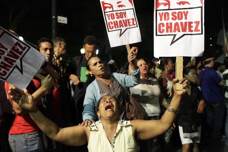 A supporter of Venezuela's President Hugo Chavez cries as she holds a sign that reads in Spanish "I am Chavez" as Chavistas gather in Bolivar square to mourn Chavez's death in Caracas, Venezuela, Tuesday, March 5, 2013. Venezuela's Vice President Nicolas Maduro announced that Chavez died on Tuesday at age 58 after a nearly two-year bout with cancer. During more than 14 years in office, Chavez routinely challenged the status quo at home and internationally. He polarized Venezuelans with his confrontational and domineering style, yet was also a masterful communicator and strategist who tapped into Venezuelan nationalism to win broad support, particularly among the poor. (AP Photo/Ariana Cubillos)