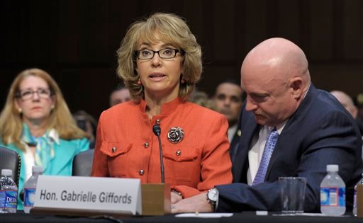 Former Arizona Rep. Gabrielle Giffords is aided by her husband, Mark Kelly, as she speaks before a Senate Judiciary Committee hearing on gun violence in this Jan. 30, 2012, photo.