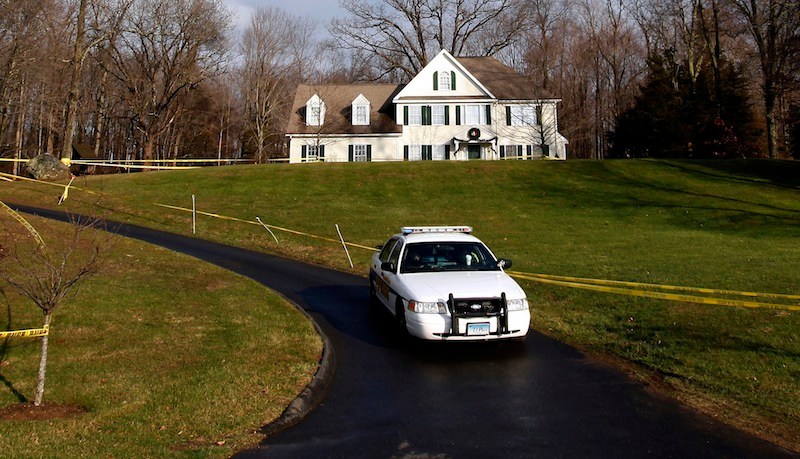 In this Dec. 18, 2012 file photo, a police cruiser sits in the driveway and crime scene tape surrounds the home of Nancy Lanza in Newtown, Conn. Nancy Lanza was killed in the home by her son Adam Lanza before he forced his way into Sandy Hook Elementary School in Newtown, Conn, killing 26 people. Search warrants released Thursday, March 28, 2013, revealed that an arsenal of weapons including guns, more than a thousand rounds of ammunition, a bayonet and several swords was seized in the Lanza home. (AP Photo/Jason DeCrow)