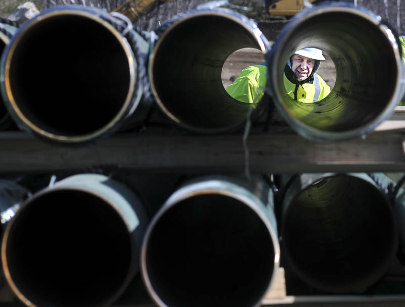 Rick Bellemare inspects a steel pipe delivered to the Windsor laydown yard of Maine Natural Gas on Monday. The firm, competing to deliver gas to Kennebec County, expects to start installing pipes in Windsor to connect a line to Augusta. Bellemare works for Enterprise Trenchless Technologies of Lisbon Falls.