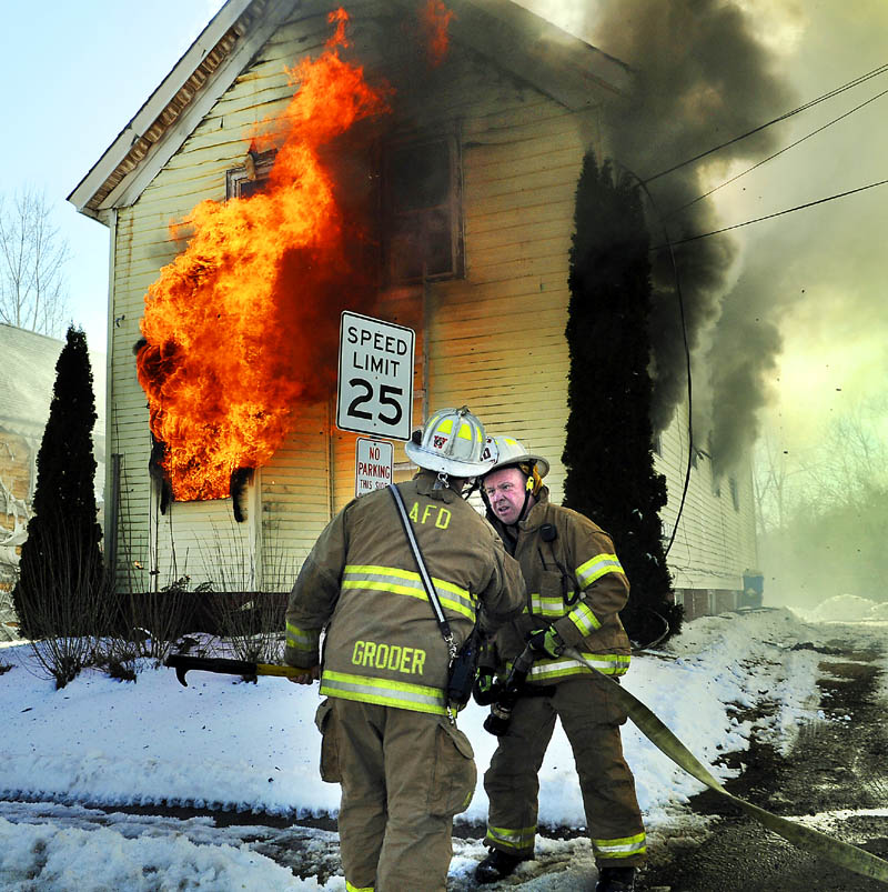 KNOCKING DOWN: Winthrop Fire Chief Dan Brooks, right, confers with Augusta Deputy Fire Chief David Groder Thursday March 21, 2013 moments after arriving a fire on Northern Avenue in Augusta. A four unit apartment building was destroyed by the afternoon blaze and one resident was injured, according to firefighters.
