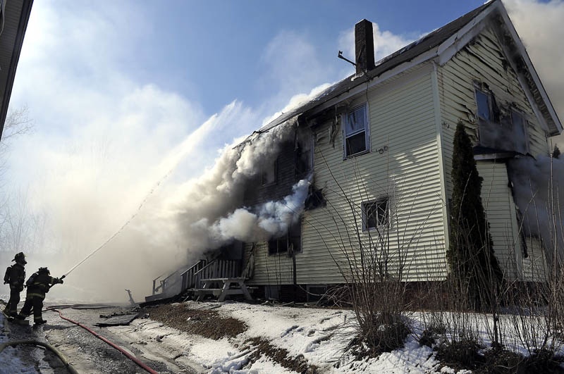 KNOCKING DOWN: Firefighters douse the rear of an apartment building on Northern Avenue in Augusta Thursday, March 21, 2013 that was consumed by fire. One resident of the building was injured, according to firefighters.