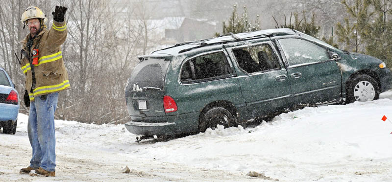 Chelsea Assistant Fire Chief Jim Gagnon directs vehicles Tuesday around a van that rolled over on the Windsor Road in Chelsea. The driver, Jesse McFadden, of Rockland, and his child were not injured in the accident, according to State Trooper James Leonard.