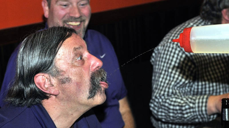 Ron Webber gulps down squirts of sake from chef Jerry Lin, at Mirakuya Steak House in Waterville Wednesday night.