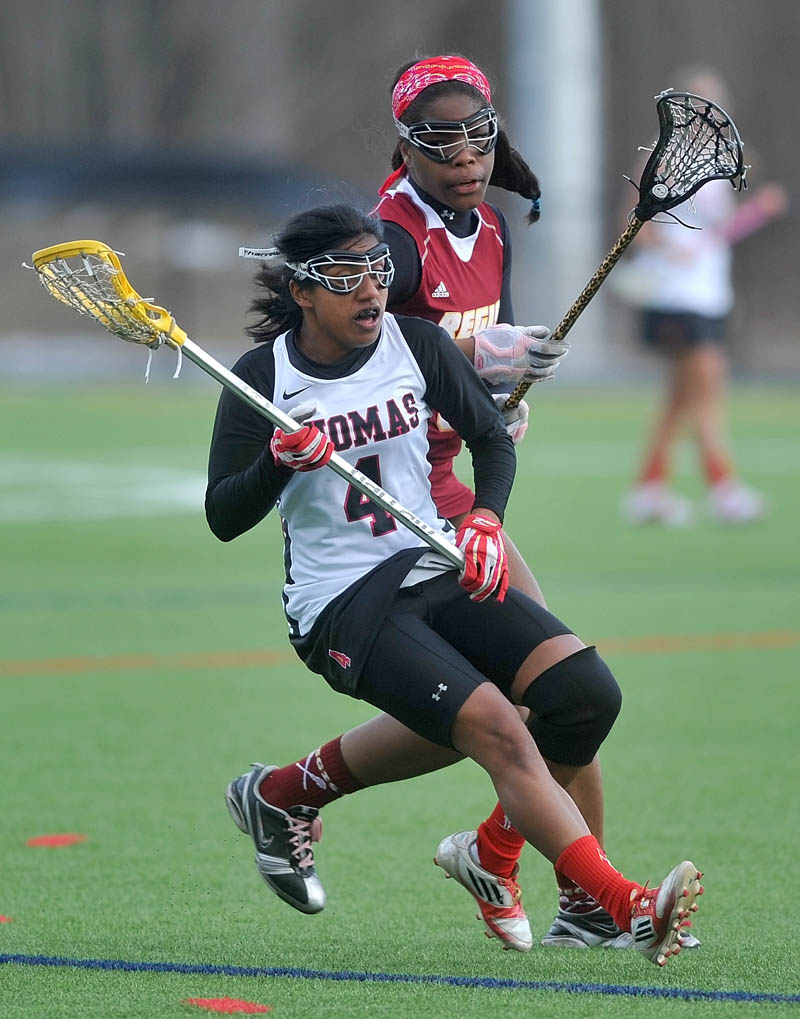 WHO’S OPEN? Thomas College’s Toral Nelson, 4, looks to pass as Regis College’s Sashae Walls, 5, defends in the second half Thursday at Thomas College in Waterville.