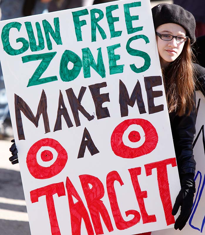 Emma Solorzano, 13, of Jefferson holds a sign at Saturday’s rally in Wiscasset.