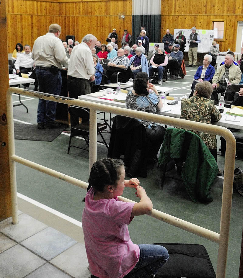 Daisy Scout Madison Wills, 6, watches the Belgrade town meeting on Saturday in the Belgrade Community Center for All Seasons. Wills was part of a group of Brownie and Girl Scouts assisting with the meeting and holding a bake sale. The Boy Scout Troop 453 color guard performed a flag ceremony to open the meeting.