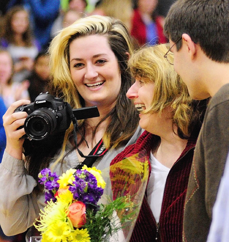 Hall-Dale High and Middle School librarian Jody Bachelder, center, hugs her children Hillary Bachelder, left, and Sam Bachelder during an assembly on Friday in the Penny Memorial Gym at Hall-Dale High School in Farmingdale. Jody Bachelder was surprised by the announcement that she won the Walter J. Taranko School Library Media Specialist of the Year award.