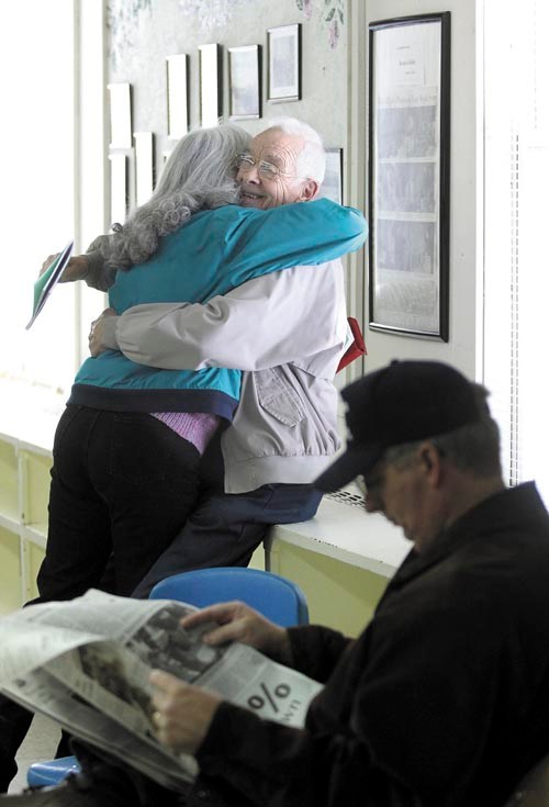 Rome resident Richard H. LaBelle smiles while getting a hug from friend Alice VanDerwerken, before the start of the annual Rome town meeting on Saturday. VanDerwerken said she and LaBelle have known each other for more than 20 years.