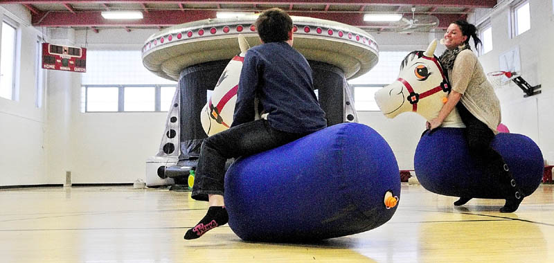 Adrian Larrabee, left, takes an early lead in a Pony Hop race against his mother, Sarah Larrabee, on Thursday, during a special event at the Augusta Boys and Girls Club in the Buker Center in Augusta. As part of the company's celebration of renovations at their Augusta restaurant, Friendly's Restaurants was paying for the party and serving ice cream sundaes at the club. They were also donating a $1 per ice cream sold this week to the club.