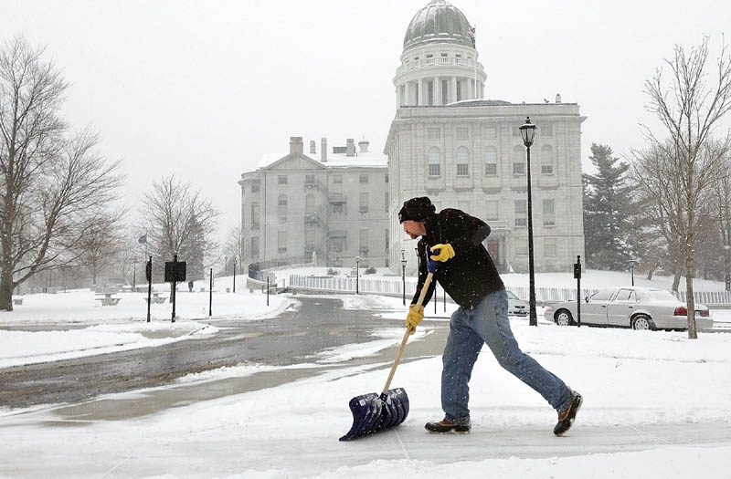 Tim Campbell shovels snow at the State House complex on Tuesday in Augusta. He was part of the Bureau of General Services crew clearing sidewalks and lots.