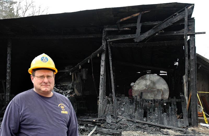 Sgt. Joel Davis of the State Fire Marshal's Office helped investigate the arson in Bingham over the weekend. Behind him is the public works garage, damaged in one of the arsons.