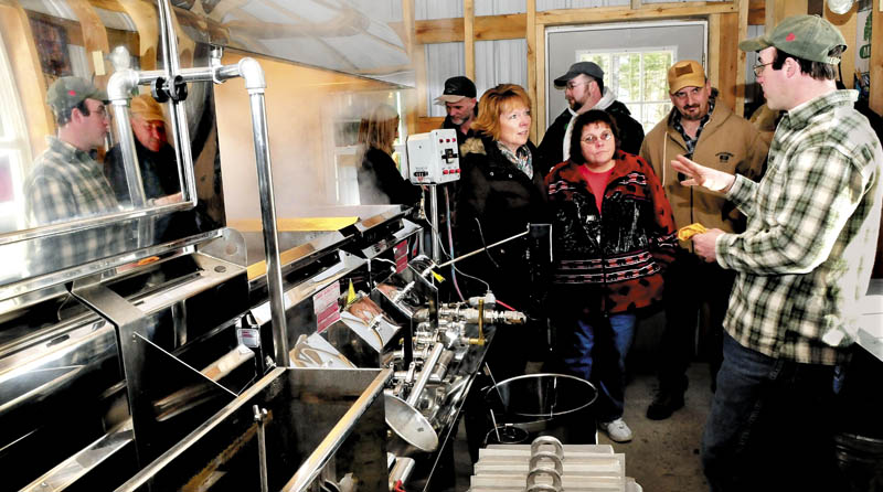 Jim Smith, right, co-owner of Smith Brothers Maple Farm in Skowhegan, on Sunday explains the process of making syrup to Claire Pish, left, and Barbara Burum, during the statewide Maine Maple Sunday event.