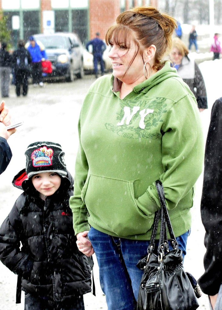 Parent Kerry Falvey holds on to her son, Jaden, after police allowed parents to reunite with their children following a lockdown of the Mill Stream Elementary School in Norridgewock on Monday. Police searched the school grounds after a report of a man nearby with a rifle.