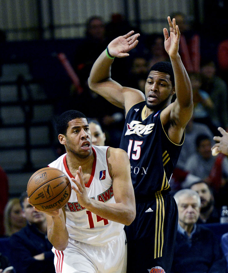 Mark Tyndale of the Red Claws looks for an open teammate while defended by Erie’s Mike Singletary.