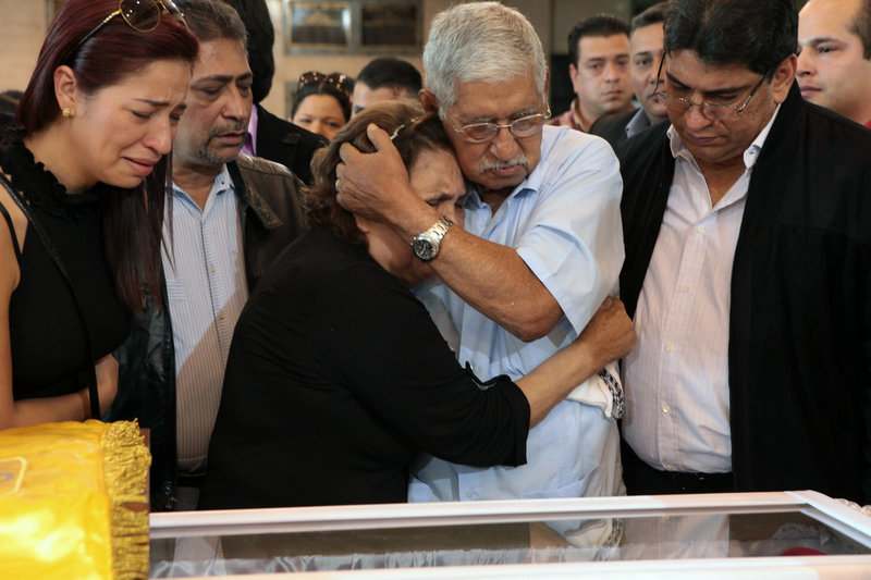 Hugo Chavez’s father, Hugo de los Reyes Chavez, center right, comforts his wife, Elena Frias, next to the coffin containing the body of Venezuela’s late President Hugo Chavez during his wake Thursday in Caracas, Venezuela.