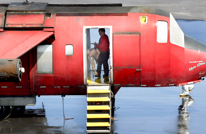 A firefighter positions a mannequin in the fuselage of an airplane for an training exercise at the Portland International Jetport on Tuesday. Part of the exercise involved firefighters rescuing mock passengers from the burning plane.
