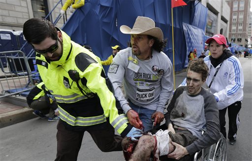 Medical responders run an injured man past the finish line the 2013 Boston Marathon following an explosion in Boston, Monday, April 15, 2013. Two explosions shattered the euphoria of the Boston Marathon finish line on Monday, sending authorities out on the course to carry off the injured while the stragglers were rerouted away from the smoking site of the blasts. (AP Photo/Charles Krupa)