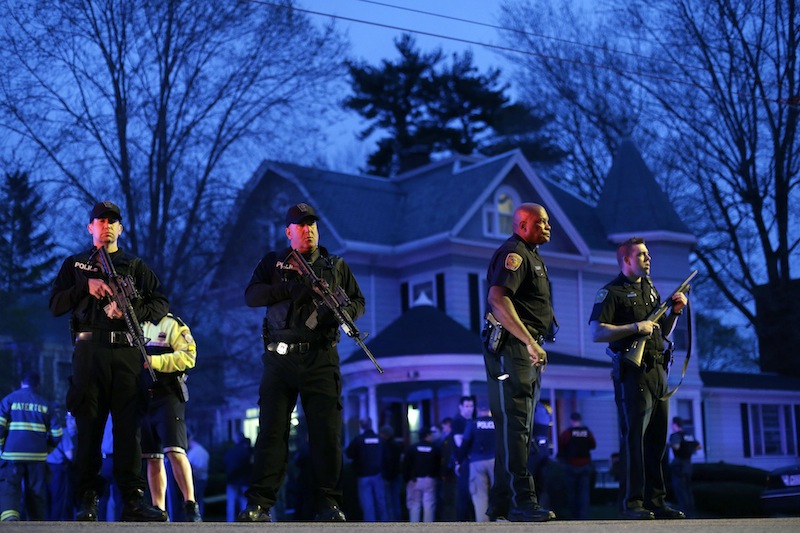 Police officers guard the entrance to Franklin street where there is an active crime scene search for the suspect in the Boston Marathon bombings, Friday, April 19, 2013, in Watertown, Mass. Gunfire erupted Friday night amid the manhunt for the surviving suspect in the Boston Marathon bombing, and police in armored vehicles and tactical gear rushed into the Watertown neighborhood in a possible break in the case. (AP Photo/Matt Rourke)