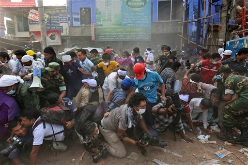 Bangladeshi rescue workers and media fall on top of each other in a stampede aftersomeone shouted that a section of building might collapse in Savar, Bangladesh, on Friday.